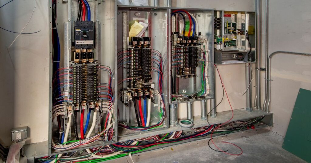 An array of cable boxes and power supplies organized in an office's technical room, illustrating essential components for office connectivity.